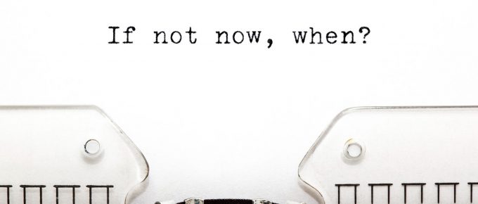 O mașină de scris veche cu cuvintele 'If Not Now When' tipărite pe o foaie de hârtie, simbolizând inspirația pentru podcasturi motivaționale și importanța acțiunii imediate în dezvoltarea personală.