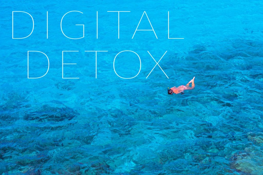 O persoană relaxându-se în mare, fără dispozitive electronice, bucurându-se de o pauză de digital detox / detoxifiere digitală